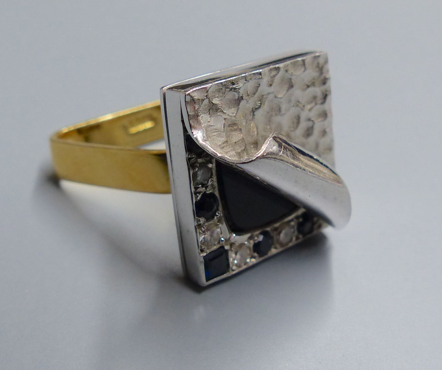 An unusual white metal, black onyx?, sapphire and diamond set square cluster ring